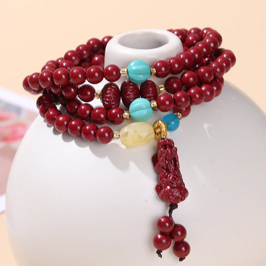 Multi-layer cinnabar bracelet with Pixiu, Peace Buckle, and Fortune Pouch charms inspired by Eastern symbolism