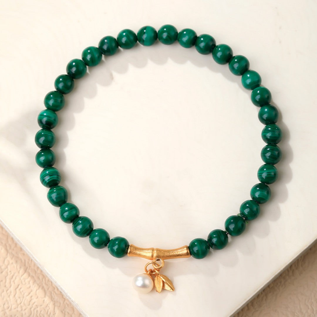 Green malachite bead bracelet with gold bamboo spacers and a white shell bead
