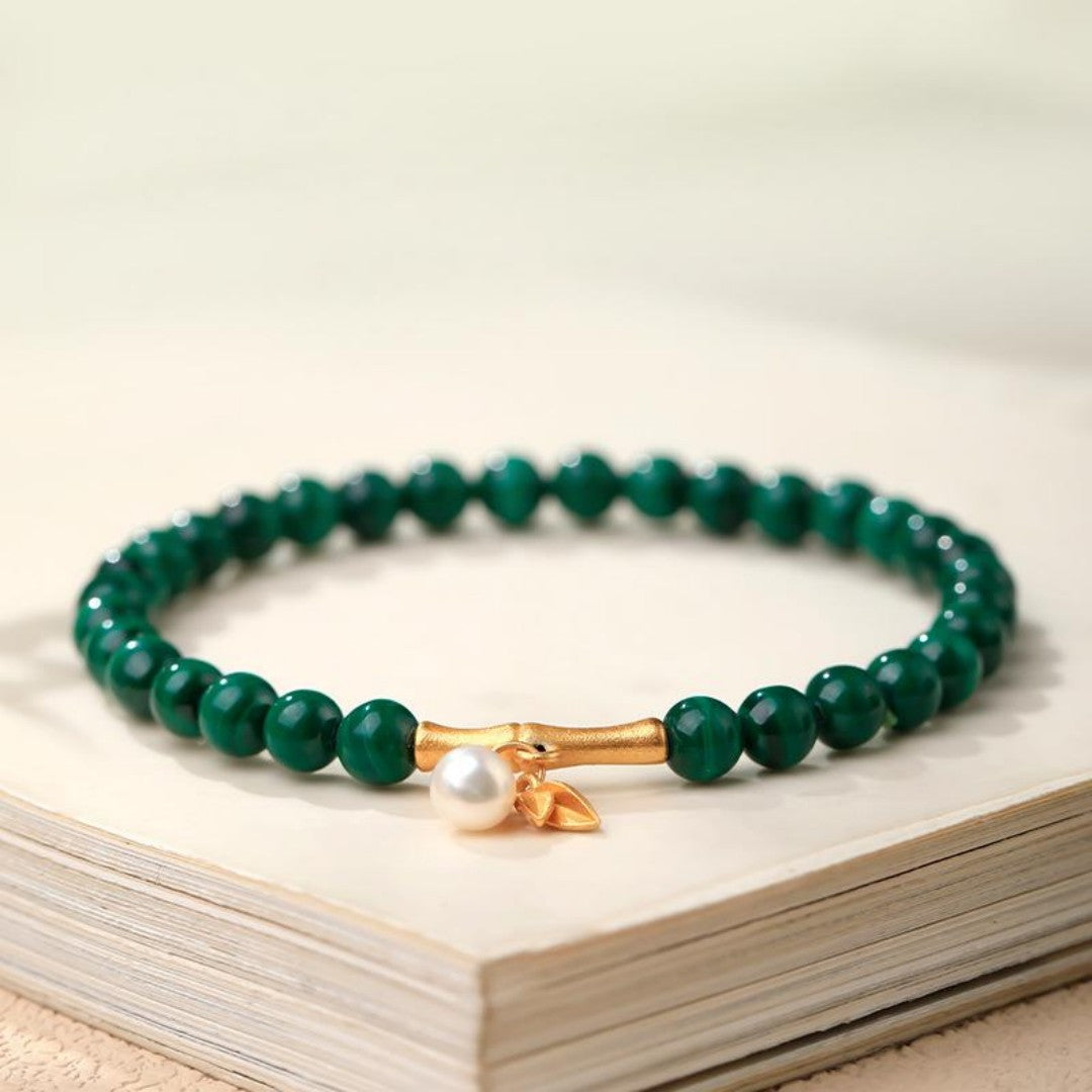 Green malachite bead bracelet with gold bamboo spacers and a white shell bead