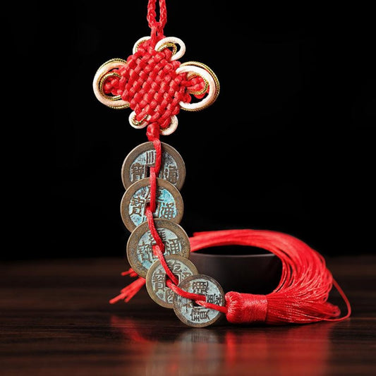 Red Chinese knot with five antique coins hanging from it (Feng Shui charm)