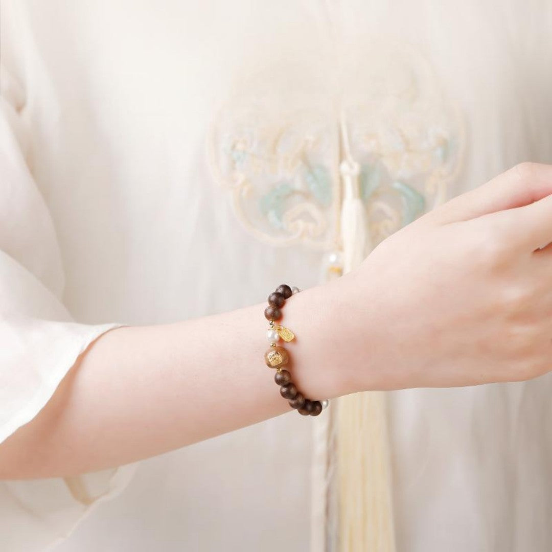 Agarwood bead bracelet with a gold-decorated Tibetan goddess carving bead and white shell beads