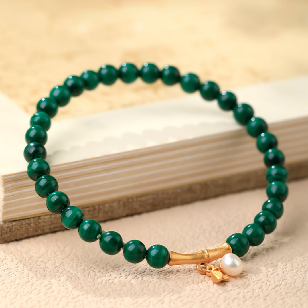 Green malachite bead bracelet with gold bamboo spacers and a white shell bead